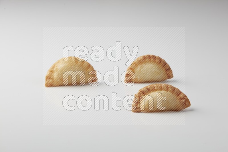 Three fried sambosas on a white background