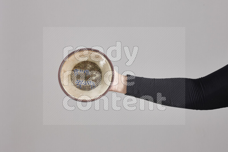 امرأة ترتدي عباءة سوداء تحمل أدوات فخارية مختلفة في أوضاع متعددة