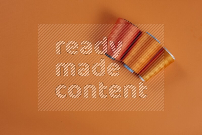 مجموعة من أدوات الخياطة والتفصيل برتقالية اللون على خلفية برتقالية