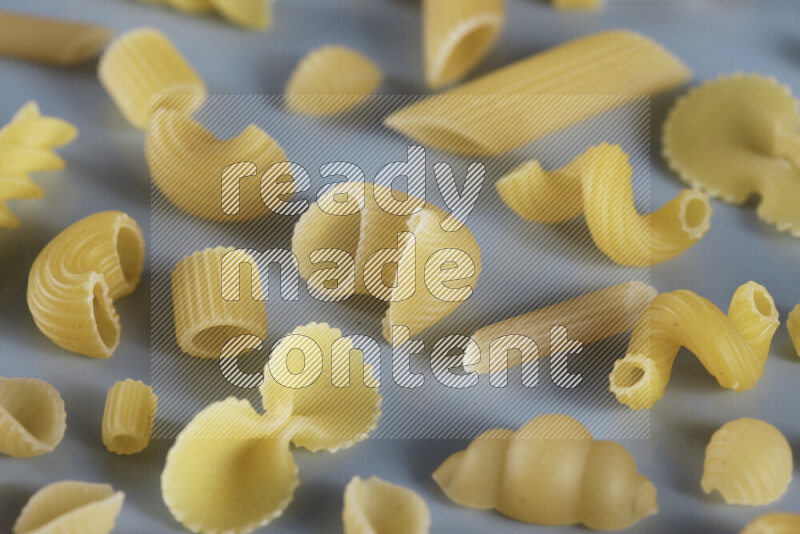 Different pasta types on light blue background