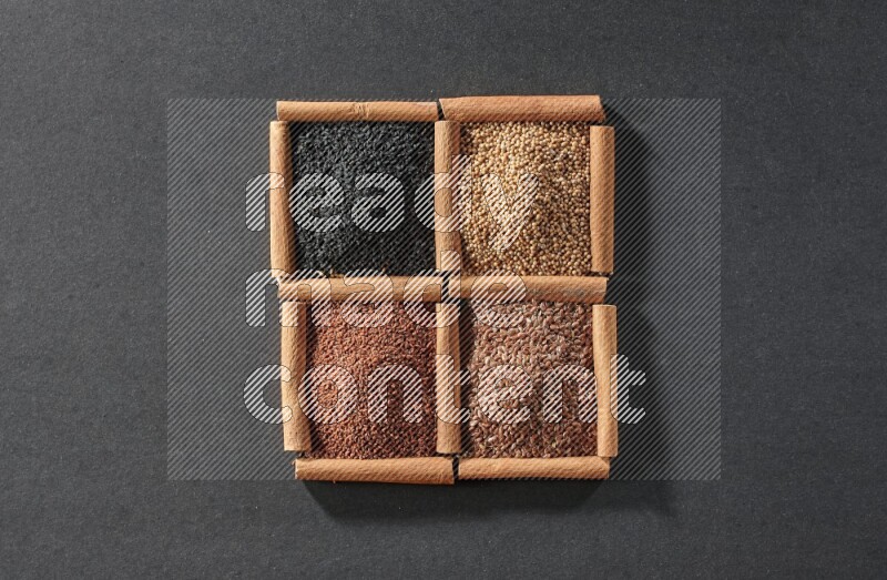 4 squares of cinnamon sticks full of flaxseeds, garden cress, black seeds and mustard seeds on black flooring