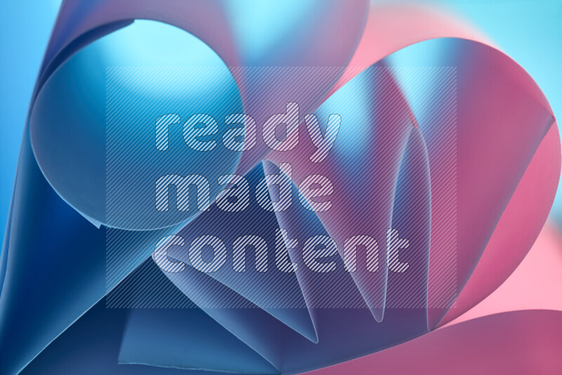 عرض فني لطيات الورق تخلق مزيج من الأشكال الهندسية، مضاءة بإضاءة ناعمة بدرجات اللون الأزرق والوردي