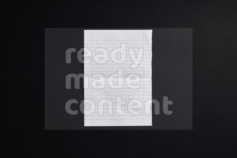 Folded notebook sheet on black background