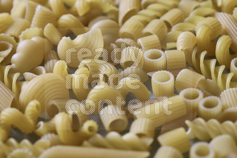 Different pasta types on light blue background