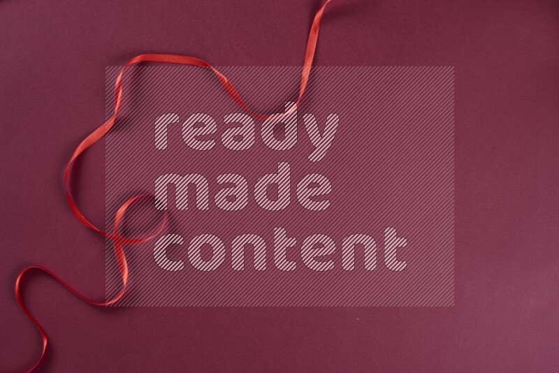 مجموعة من أدوات الخياطة والتفصيل حمراء اللون على خلفية حمراء