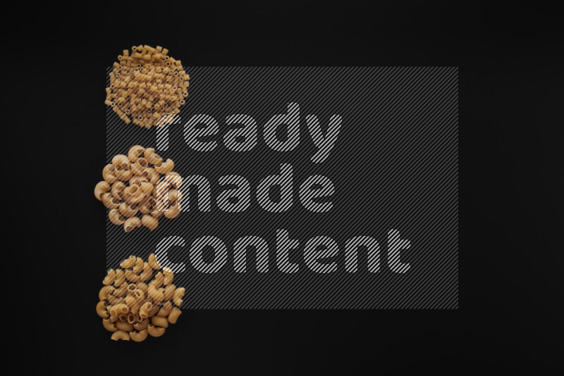 Different pasta types in 3 bunches on black background