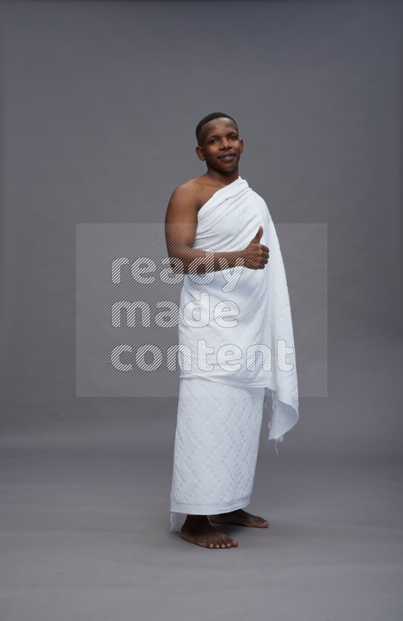 A man wearing Ehram Standing Interacting with the camera on gray background