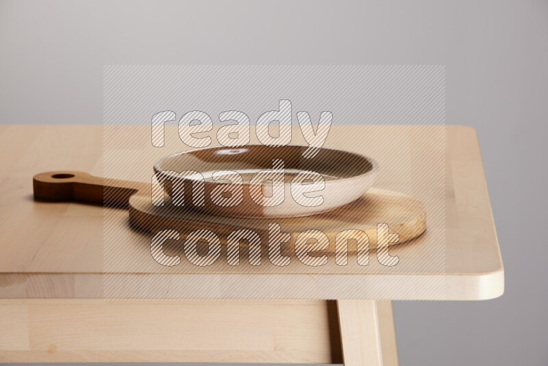 multi colored plate placed on a  wooden oval cutting board on the edge of wooden table