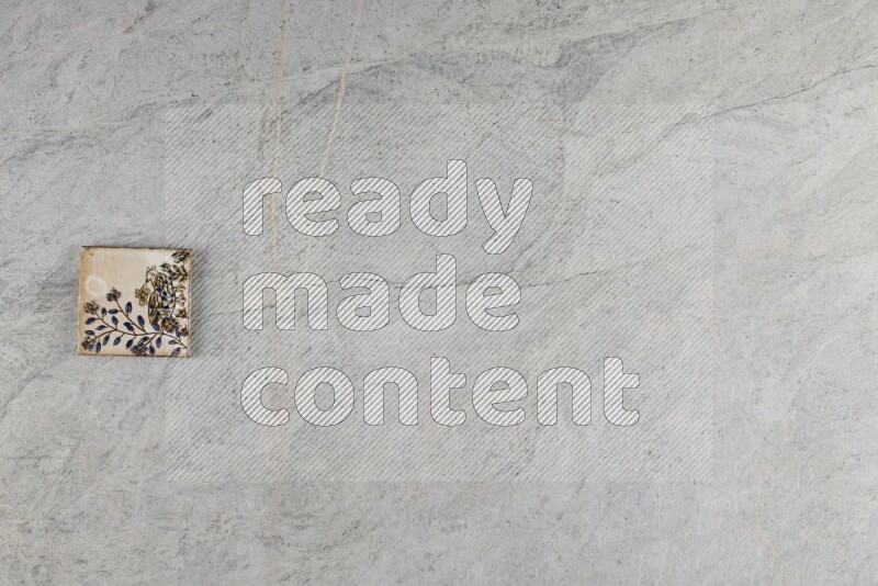 A decorative pottery coaster on grey marble background