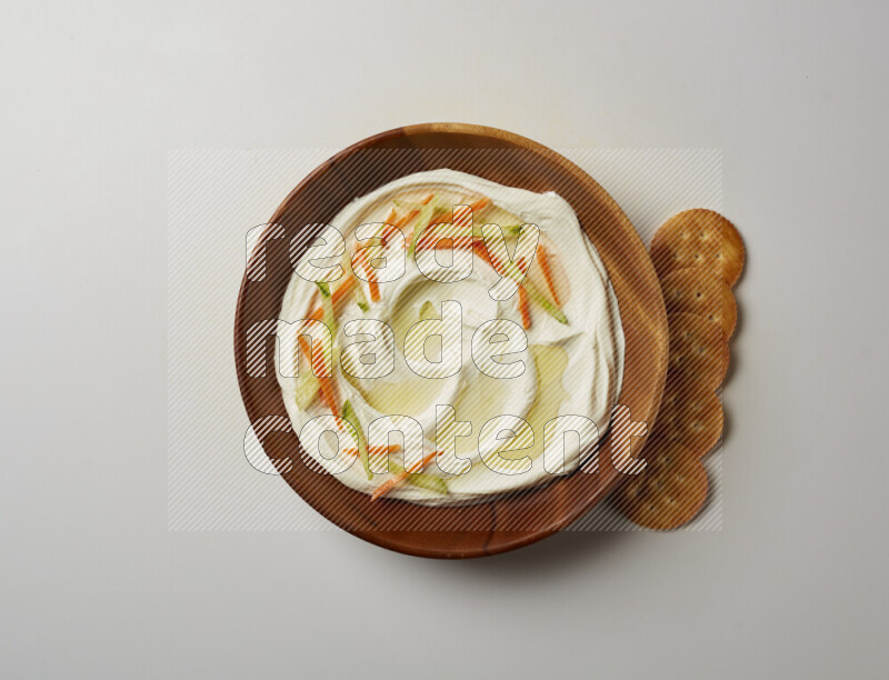 Lebnah garnished with sliced carrots & cucumber in a wooden plate on a white background