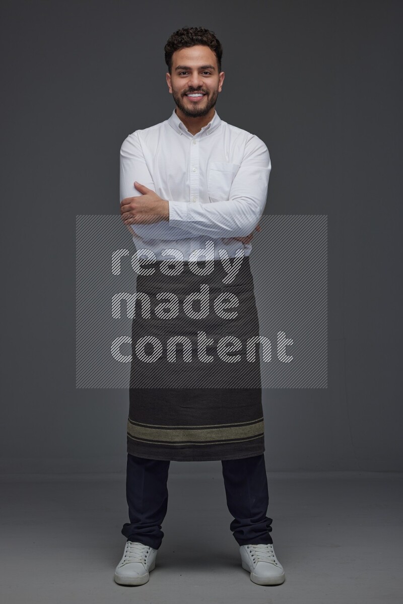 A man wearing smart casual and apron standing and making multi poses eye level on a gray background