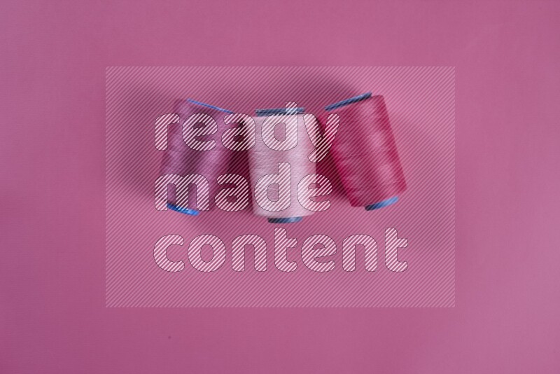 A pink collection of sewing and tailoring tools arranged on a pink background