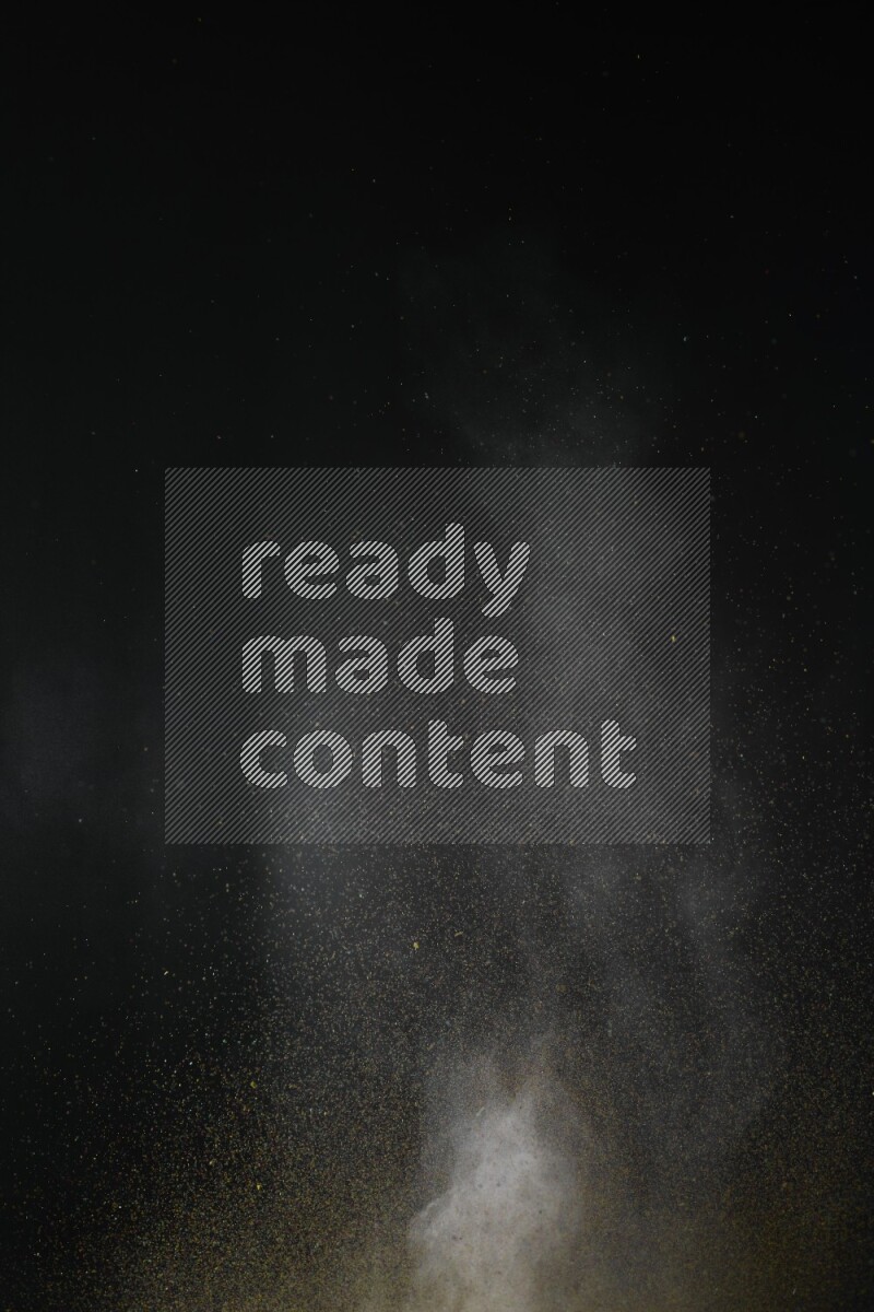 A side view of brown powder explosion on black background