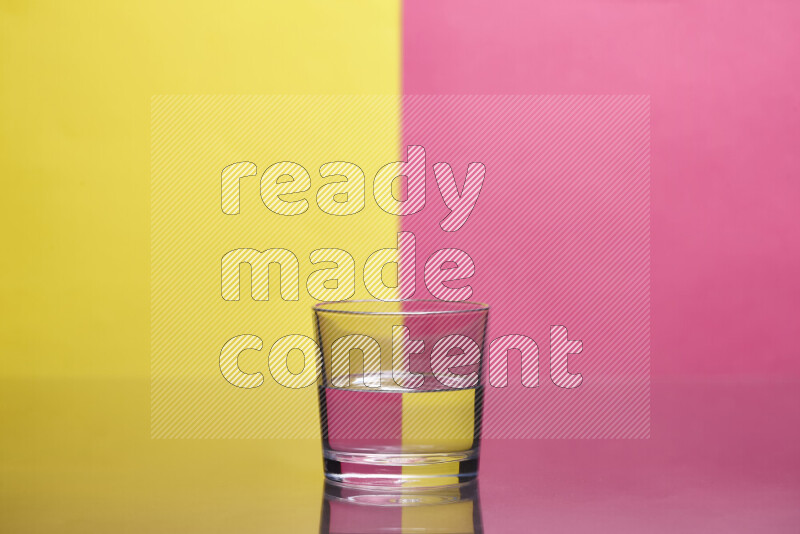 The image features a clear glassware filled with water, set against yellow and pink background