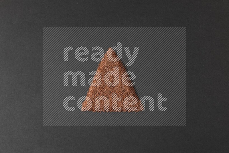 Garden cress seeds in a triangle shape on a black flooring