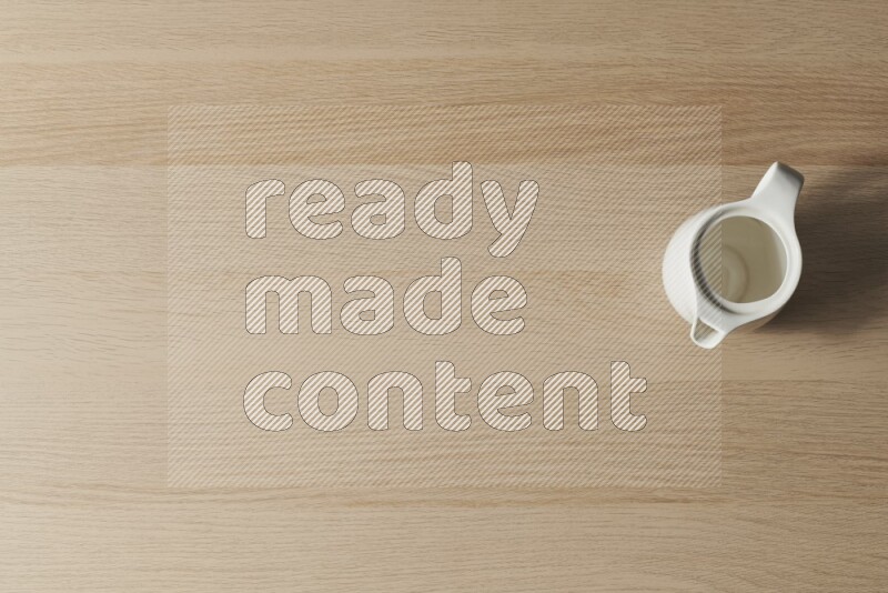 A ceramic milk jug on light wooden background