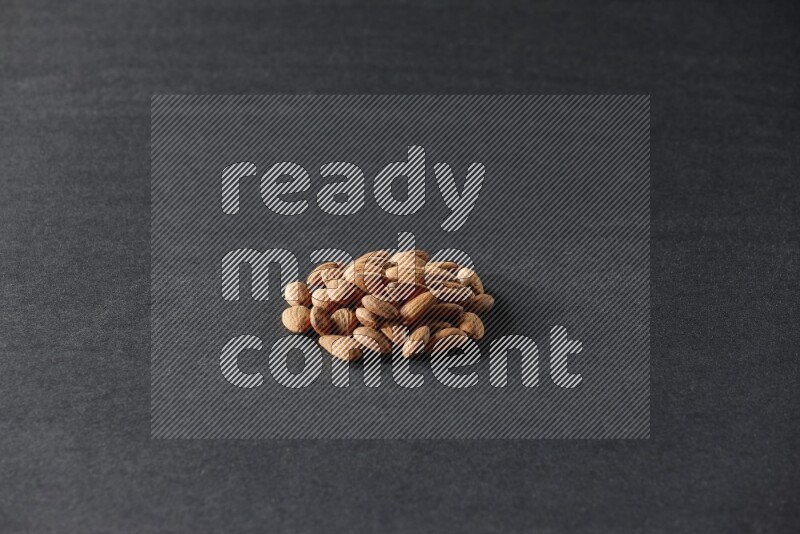A bunch of peeled almonds on a black background in different angles