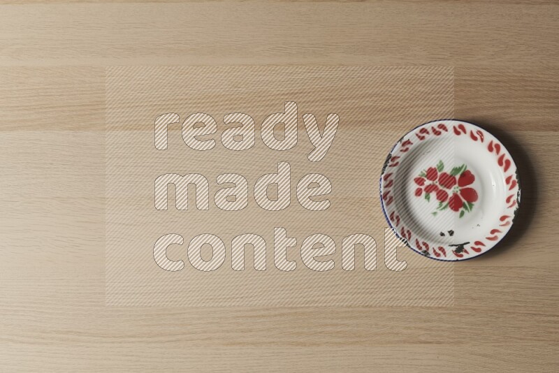 صحن معدني عتيق على خلفية خشبية فاتحة