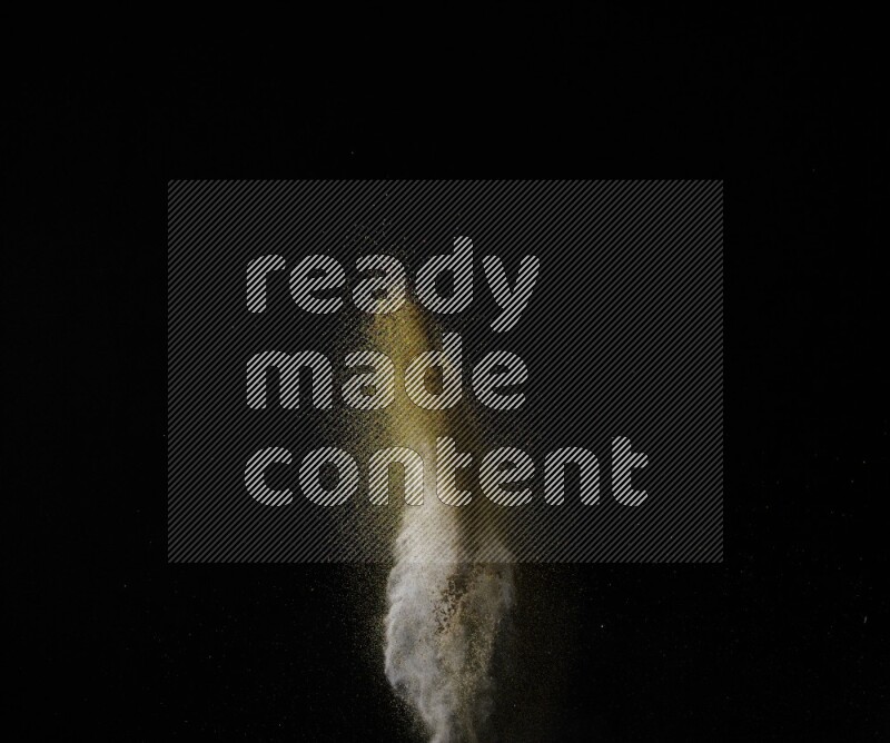 A side view of brown powder explosion on black background