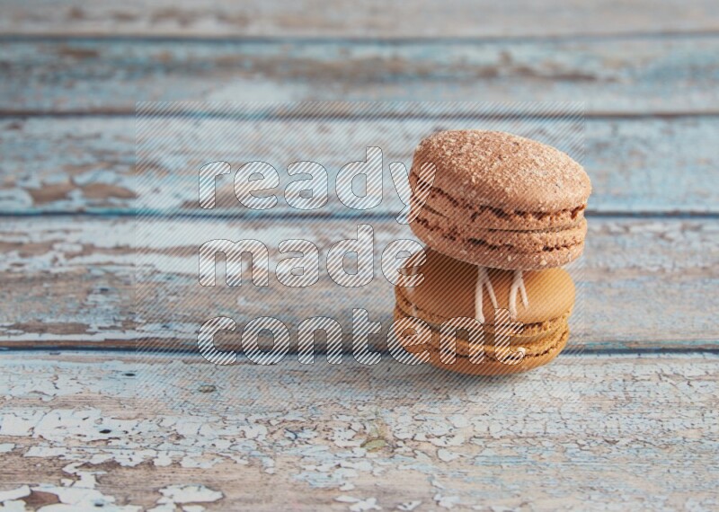 45º Shot of of two assorted Brown Irish Cream, and Brown Hazelnuts macarons  on light blue background