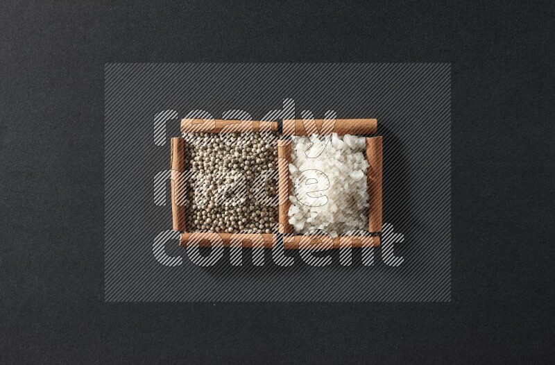 2 squares of cinnamon sticks full of white pepper and salt on black flooring