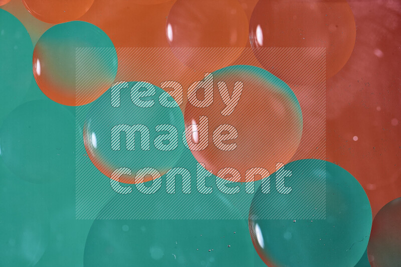 Close-ups of abstract oil bubbles on water surface in shades of green and orange