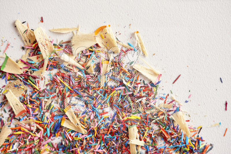 This image showcases a vibrant multicolored pencil shavings scattered on grey background