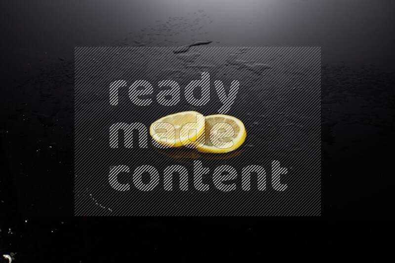 Lemon slices with water drops, and droplets on black background