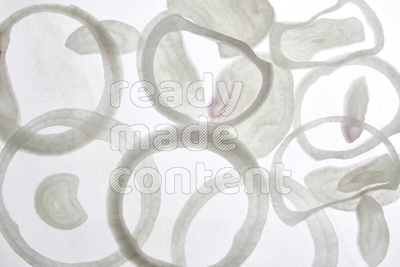 Onion slices on illuminated white background