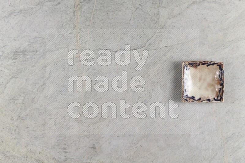 A decorative pottery plate on grey marble background