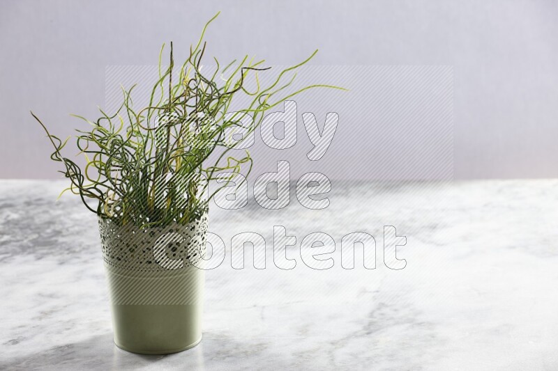 Artificial plant in green decorative pot on grey marble background