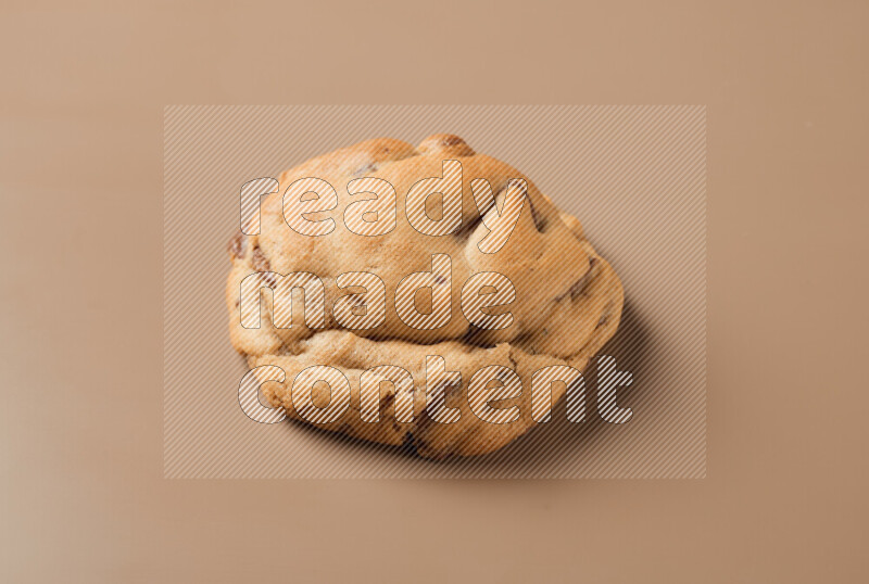 a whole chocolate chip cookie on a brown background