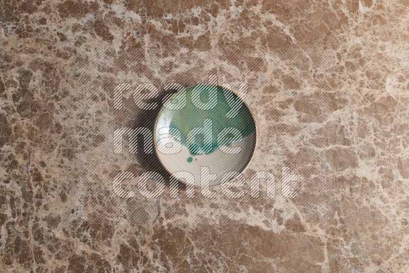 A decorative pottery plate on beige marble background