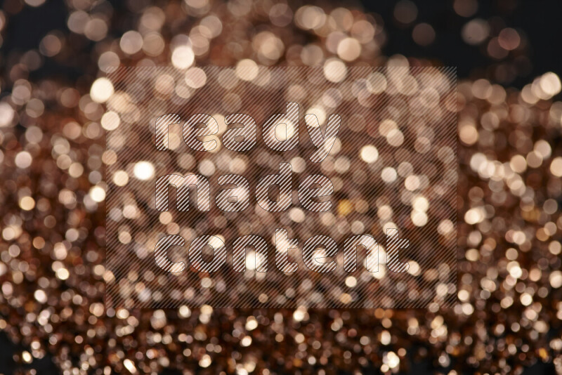 قطع زجاجية برونزية لامعة متناثرة على خلفية سوداء