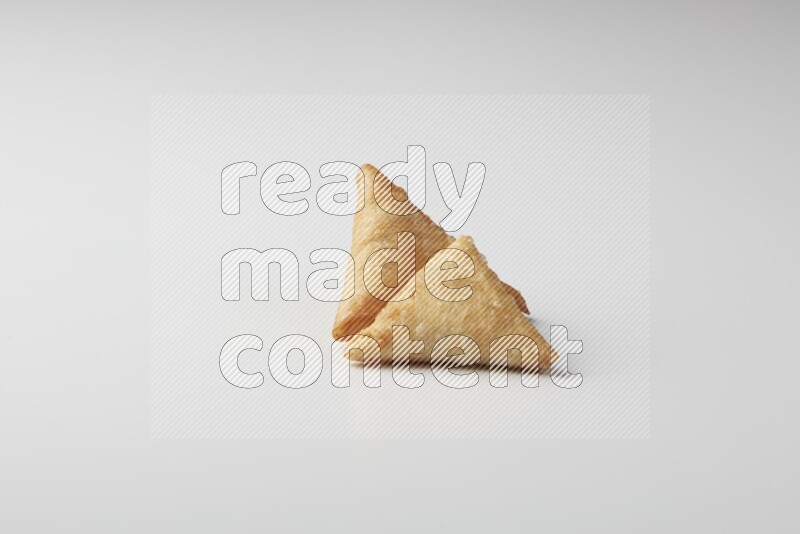 Two fried sambosas on a white background