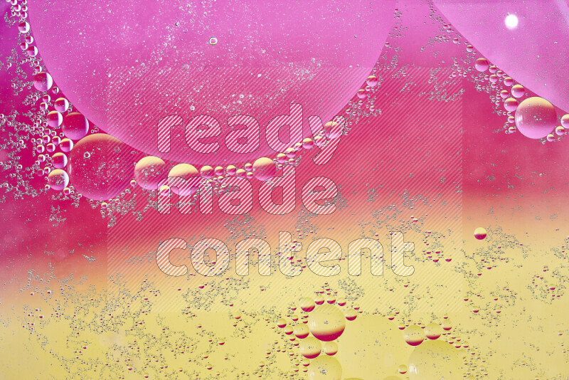 Close-ups of abstract oil bubbles on water surface in shades of yellow and pink