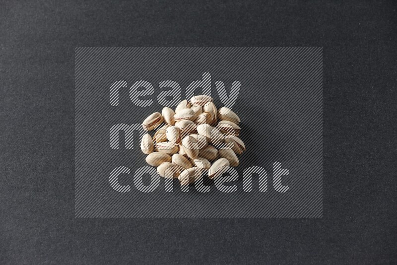 A bunch of pistachios on a black background in different angles