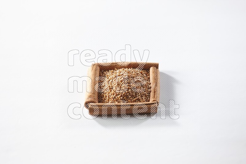 A single square of cinnamon sticks full of mustard seeds on white flooring