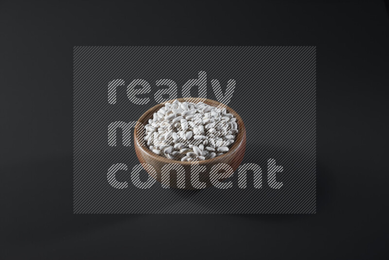 Snacks in a wooden bowl on grey background