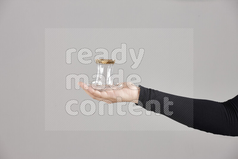 A woman in black abaya holding different glassware in different positions