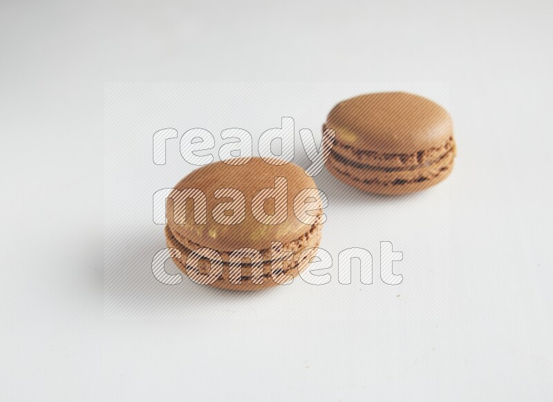 45º Shot of two Brown Coffee macarons on white background