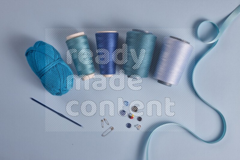 A blue collection of sewing and tailoring tools arranged on a blue background