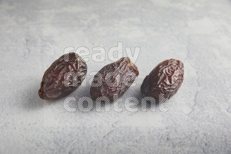 three madjoul dates on a light grey background