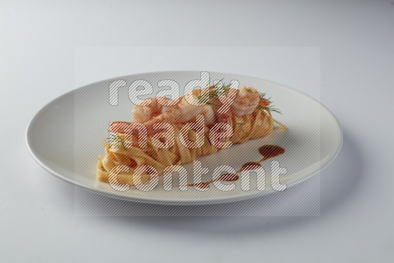 Fettuccini red sauce pasta with shrimp in a white plate on a white background
