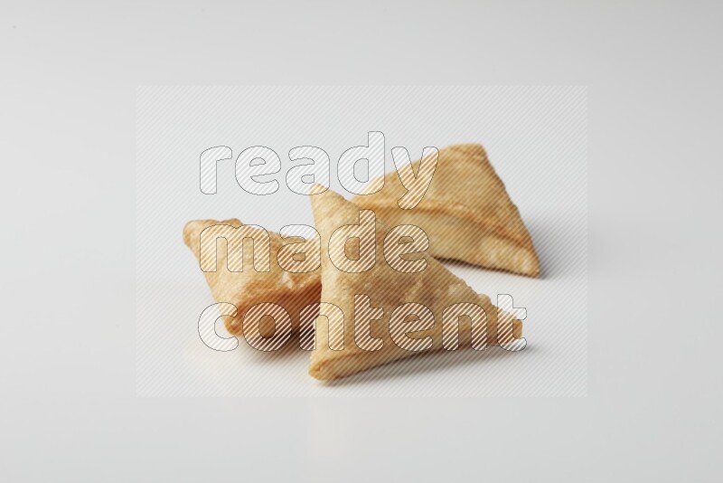 Three fried sambosas on a white background