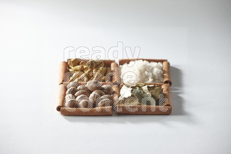 4 squares of cinnamon sticks full of salt, bay laurel, nutmeg, turmeric on white flooring