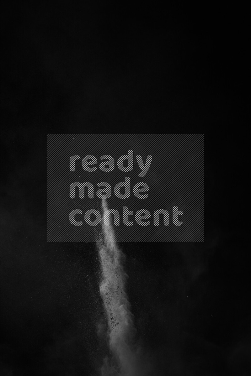 A side view of white powder explosion on black background