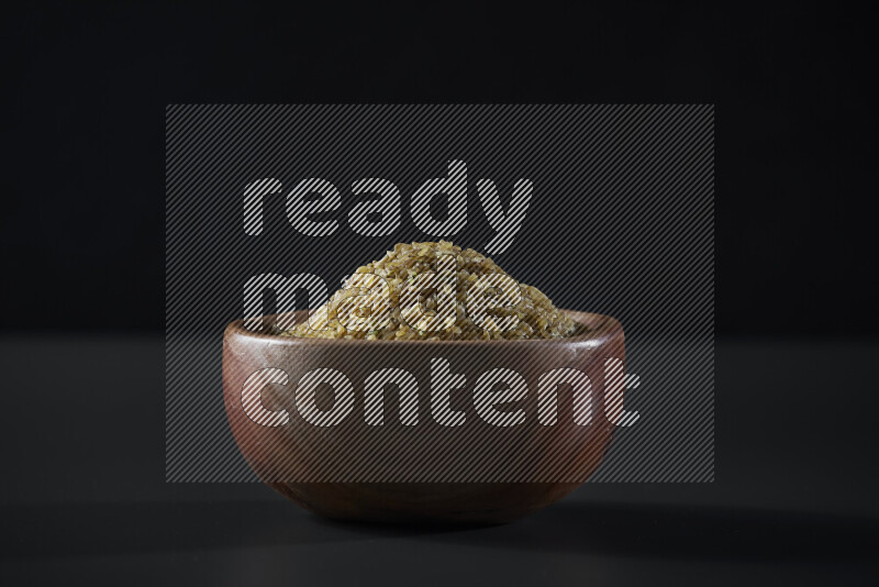 Coarse bulgur in a wooden bowl on grey background