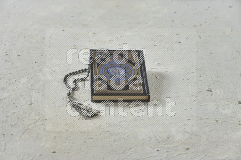 Quran with a prayer beads on white background