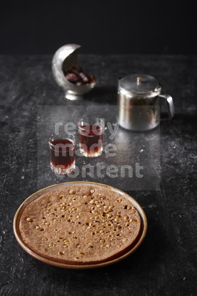 Basbousa with tea in a dark setup